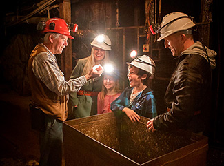 Tour Guide showing a family a gold nugget on an underground Mine Experience Tour at Central Deborah Gold Mine